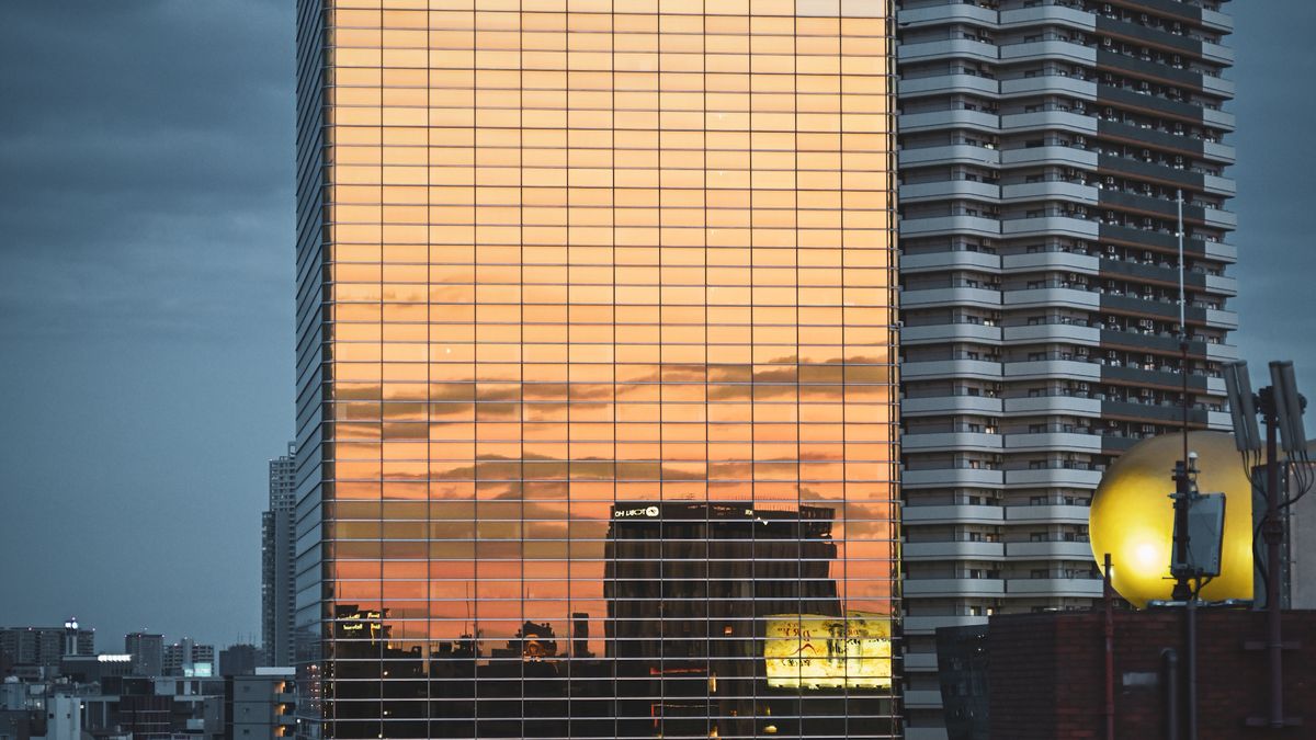 夕日を映す高層オフィスビルのガラス面